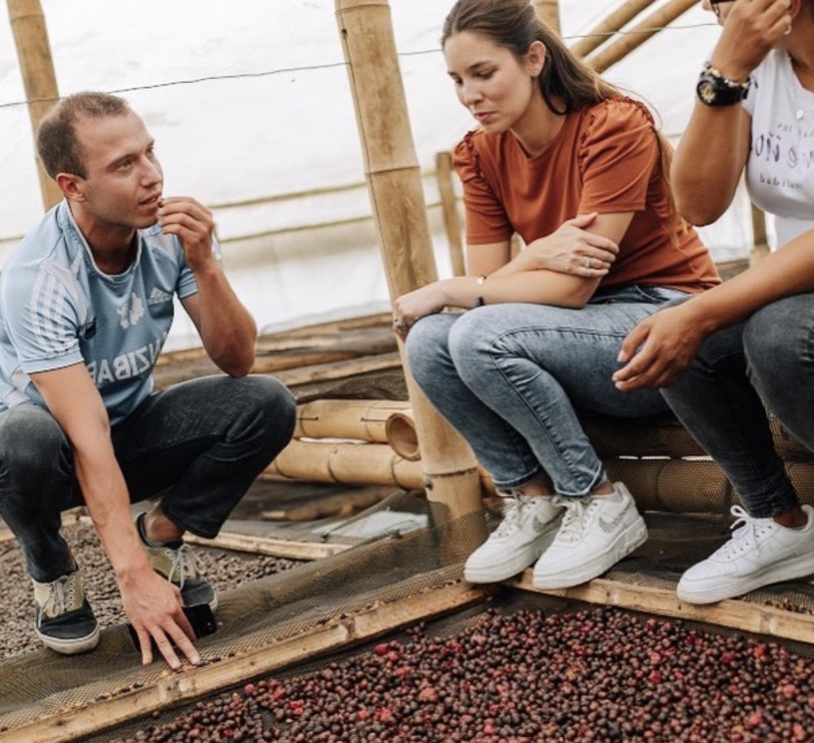 Maria Palacio of Progeny Coffee with two farmers and drying coffee