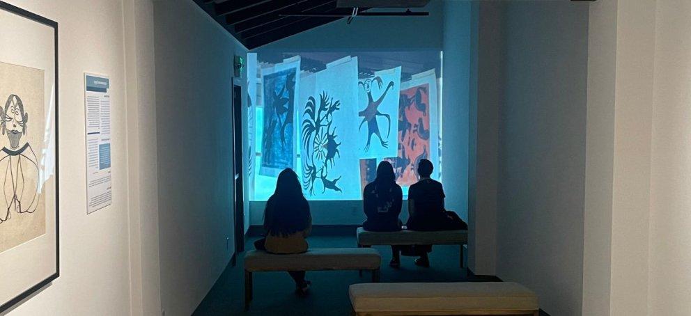 参观者在博物馆画廊观看墙上的投影. 